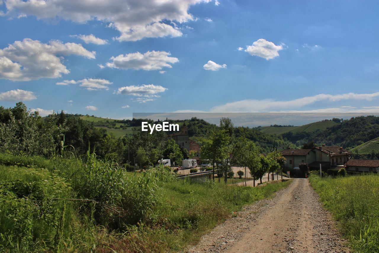 Scenic view of trees and houses against sky