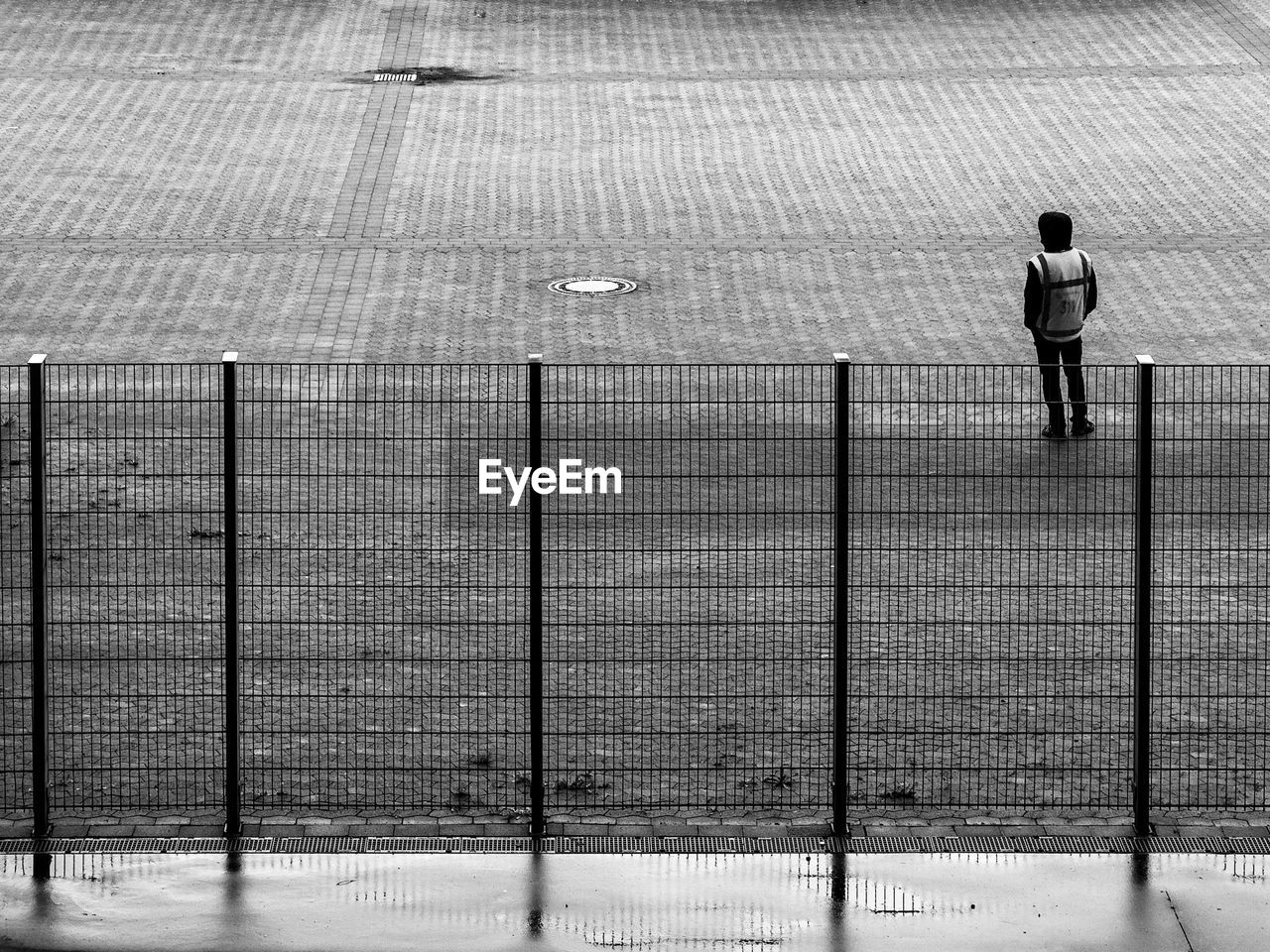 black and white, black, monochrome, full length, white, one person, monochrome photography, line, men, day, leisure activity, lifestyles, standing, architecture, walking, rear view, nature, outdoors, built structure, sports, snow, adult, sunlight, fence