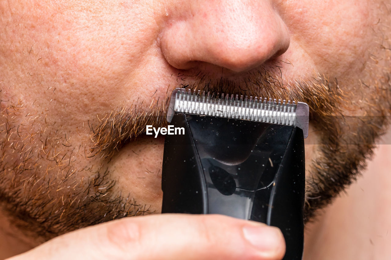 Close-up of man shaving