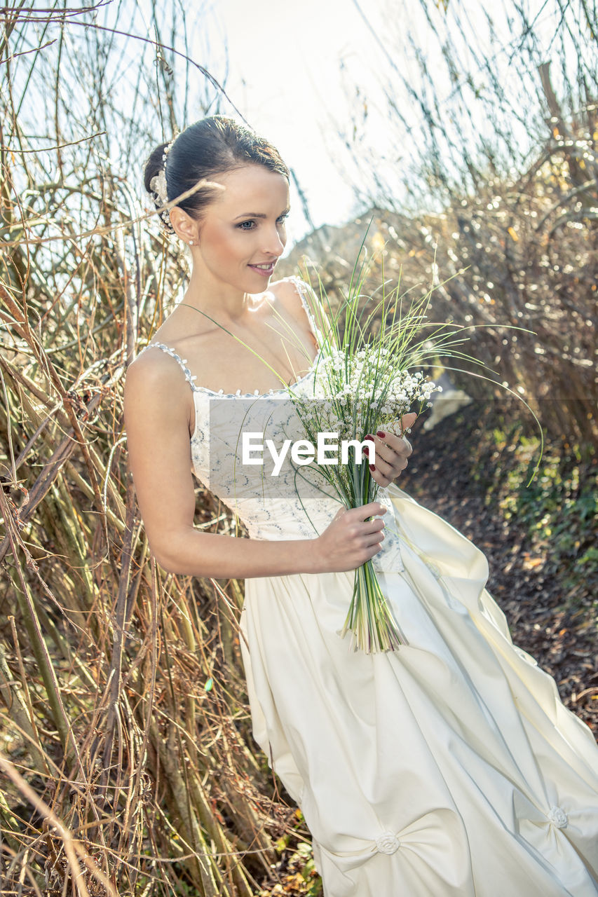 Bride standing on field against sky