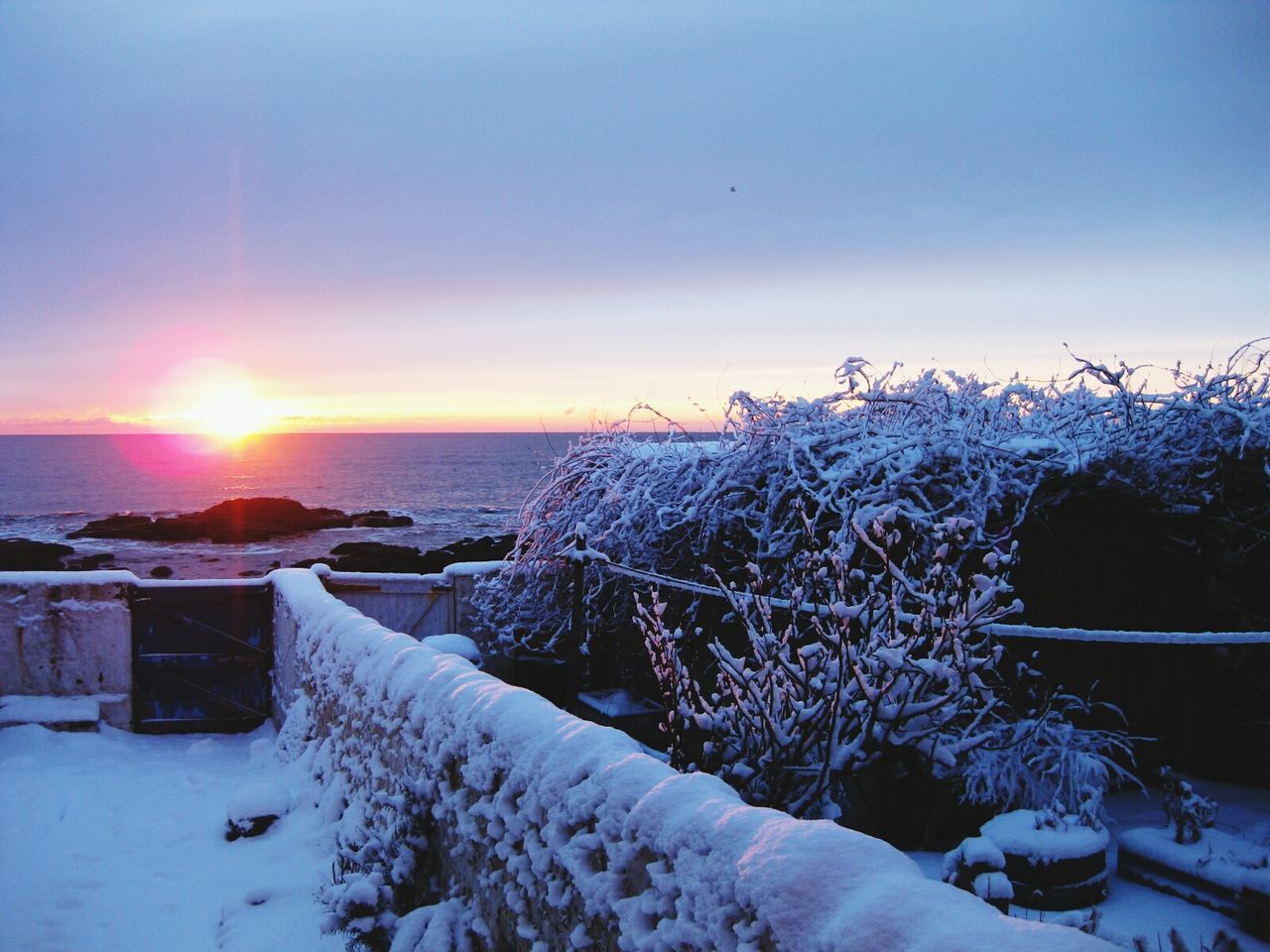 Scenic view of frozen lake against sky during sunset