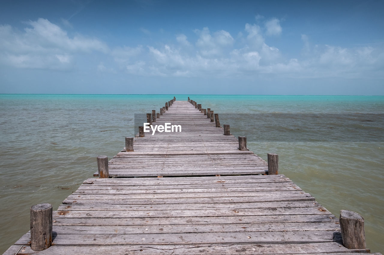 WOODEN PIER LEADING TOWARDS SEA AGAINST SKY