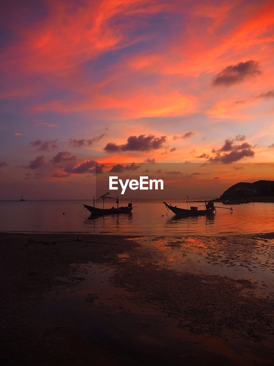 Silhouette boats moored on sea by shore against sky during sunset