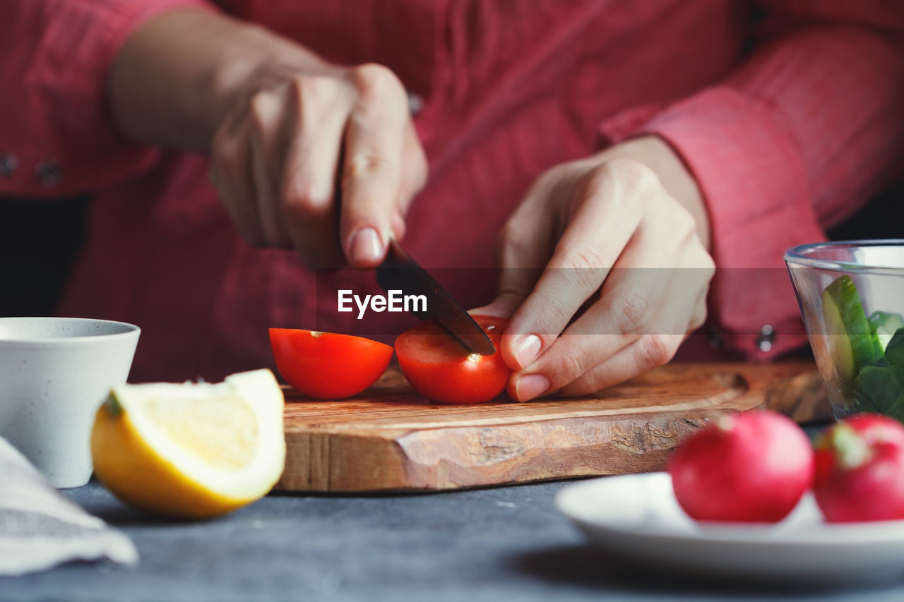 Midsection of woman cooking food at table