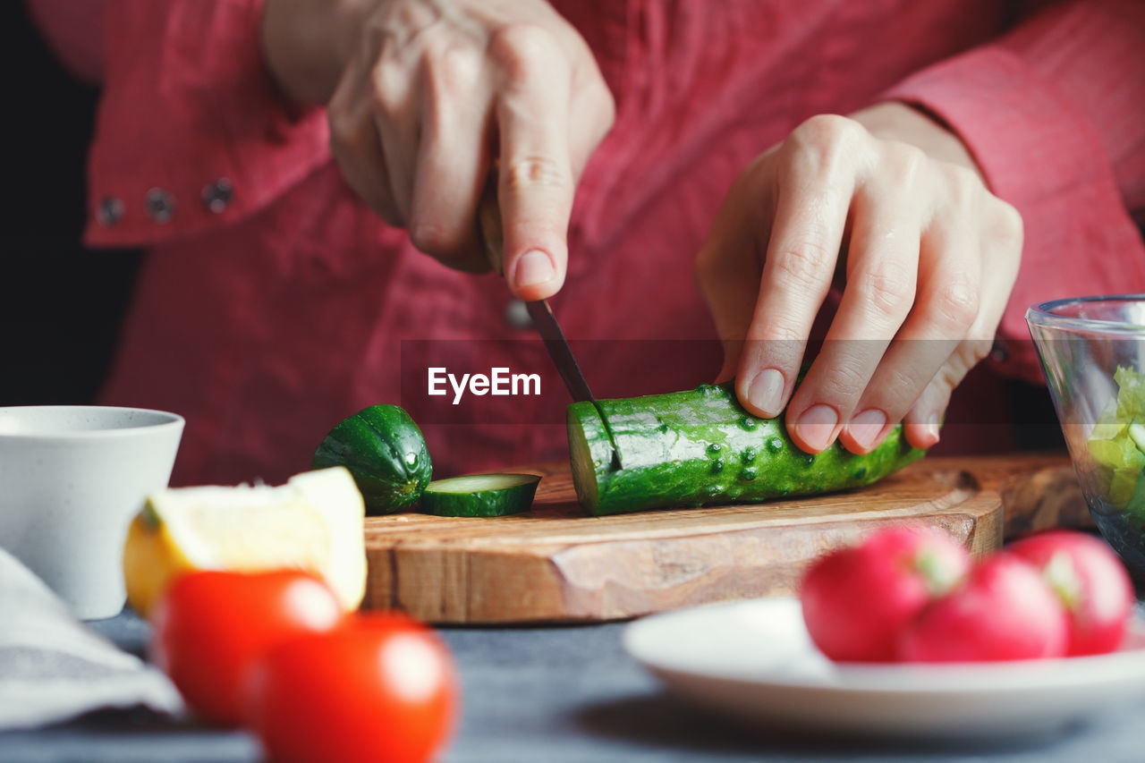 Midsection of woman cooking food at table