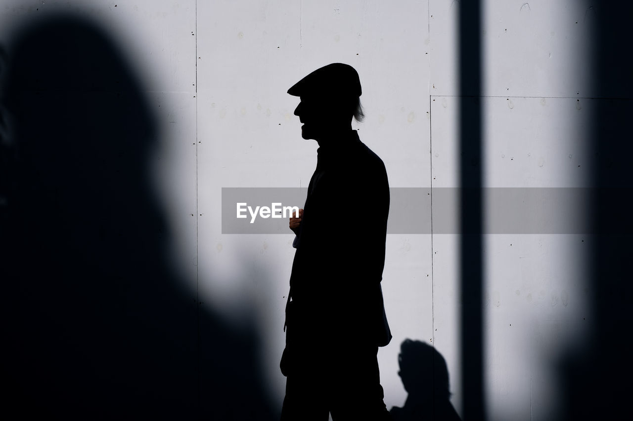 Side silhouette view of old man with cap