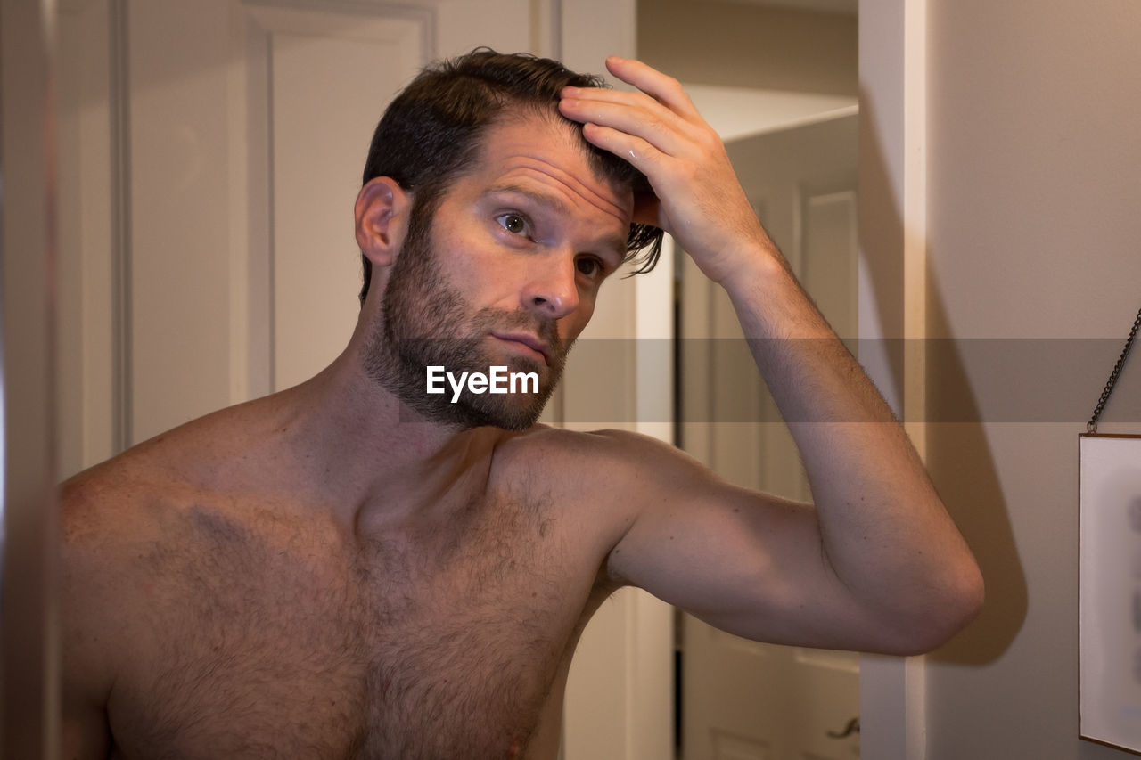 PORTRAIT OF MAN IN BATHROOM