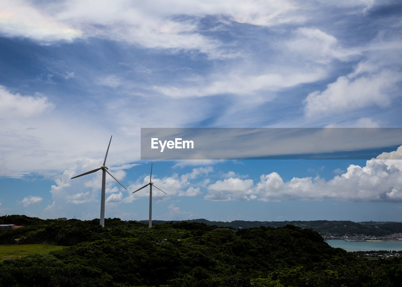 Low angle view of windmills against sky