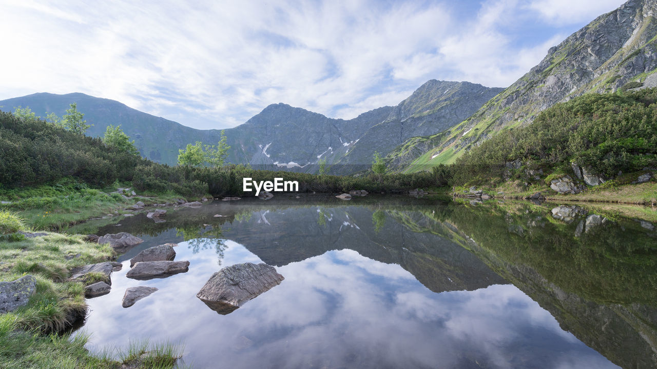 mountain, water, scenics - nature, beauty in nature, environment, landscape, mountain range, lake, sky, nature, reflection, cloud, wilderness, plant, tranquility, tree, land, forest, tranquil scene, no people, travel destinations, travel, pine tree, valley, pinaceae, non-urban scene, coniferous tree, pine woodland, outdoors, activity, tourism, idyllic, rock, day, mountain peak, highland, summer, blue, reservoir, leisure activity