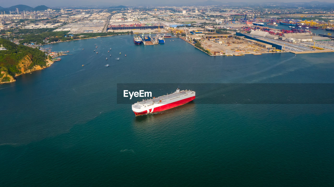 Aerial view ro-ro ship loading new cars. automotive container carriers sailing on the sea 