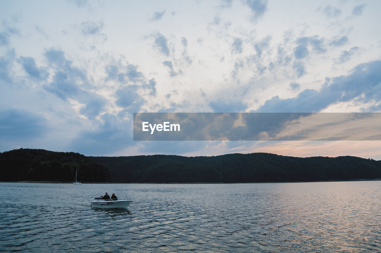 SCENIC VIEW OF SEA AGAINST MOUNTAIN