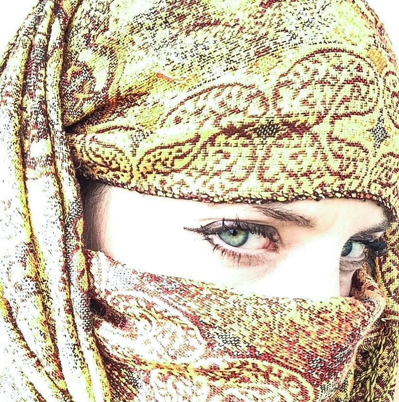 Close-up portrait of a beautiful green eyed woman wearing headscarf