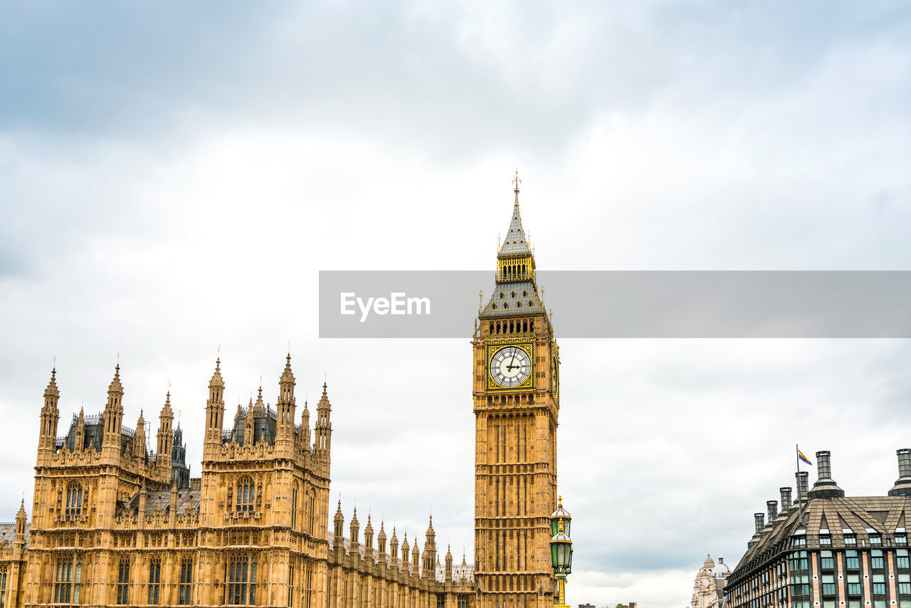 Low angle view of big ben in city against cloudy sky