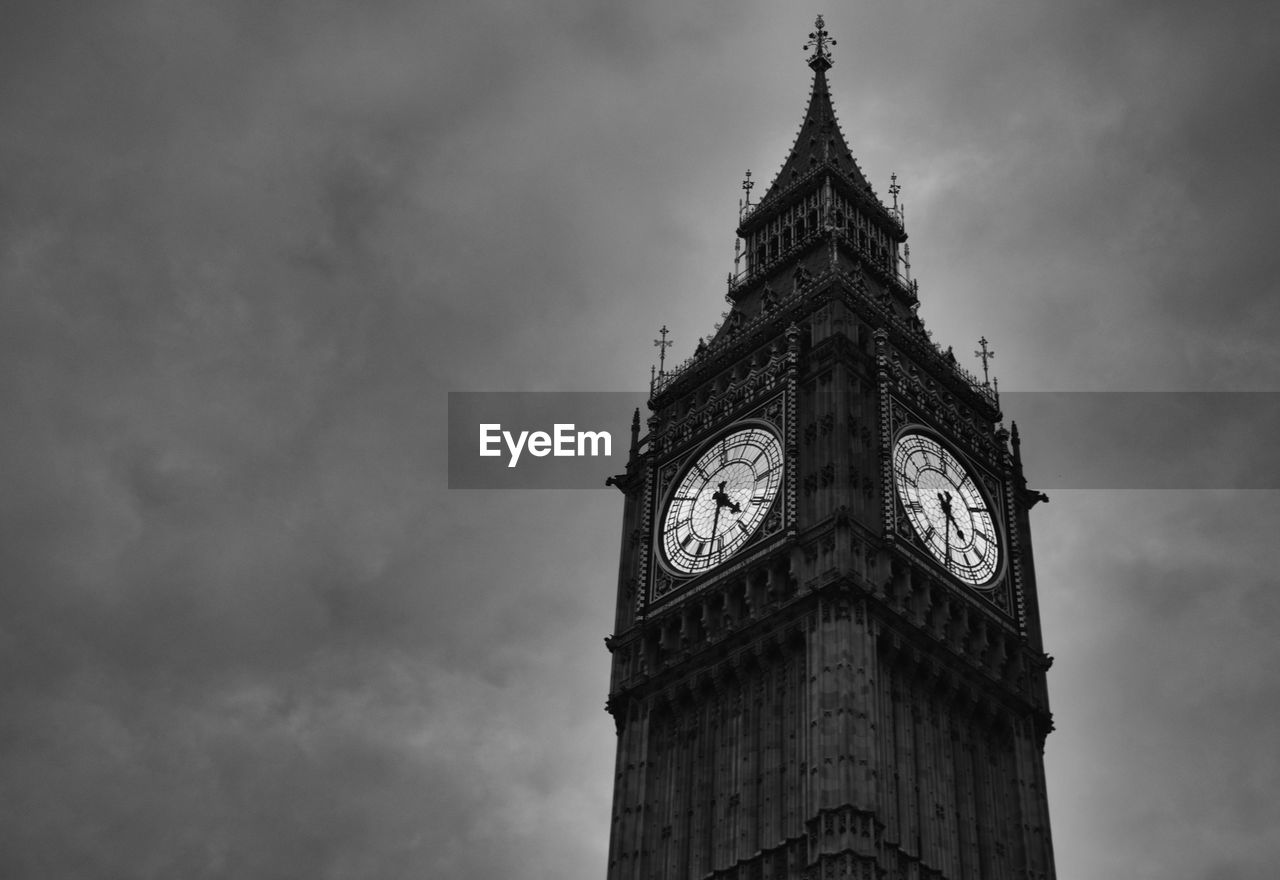 Low angle view of clock tower against cloudy sky