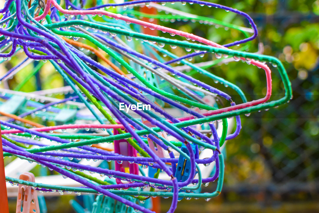 Close-up of wet colorful coat hangers