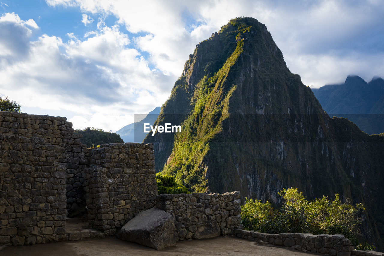 STONE WALL WITH MOUNTAINS IN BACKGROUND