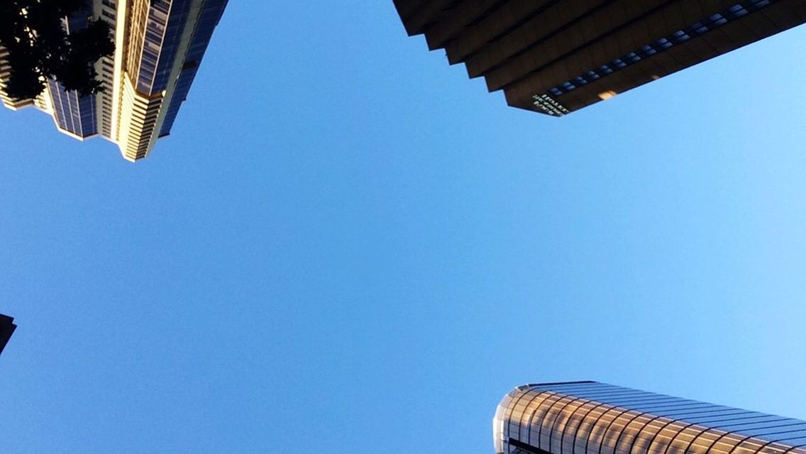 LOW ANGLE VIEW OF TALL BUILDING AGAINST CLEAR BLUE SKY