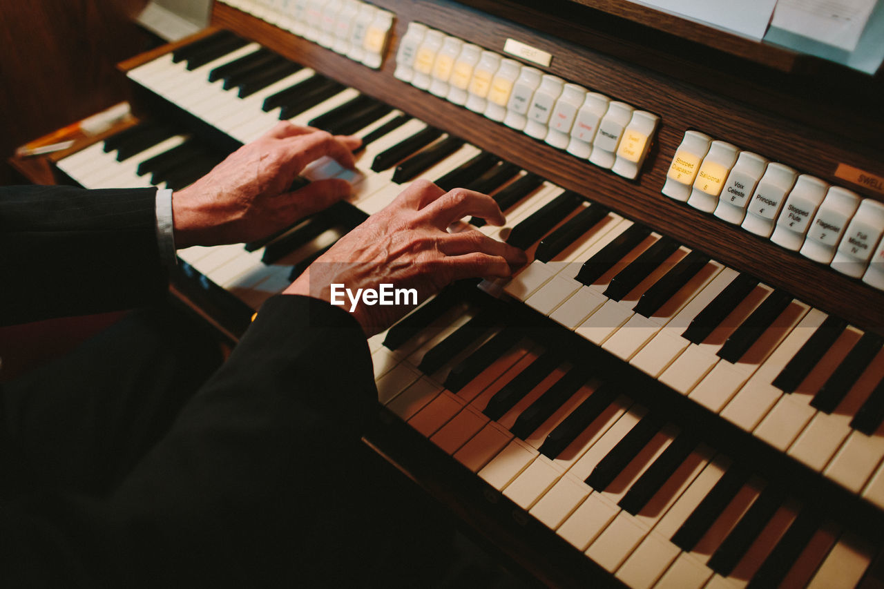 Close-up of man playing organ