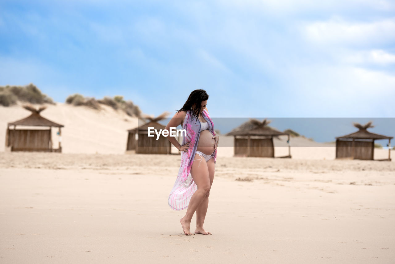 Full length of woman on beach against sky