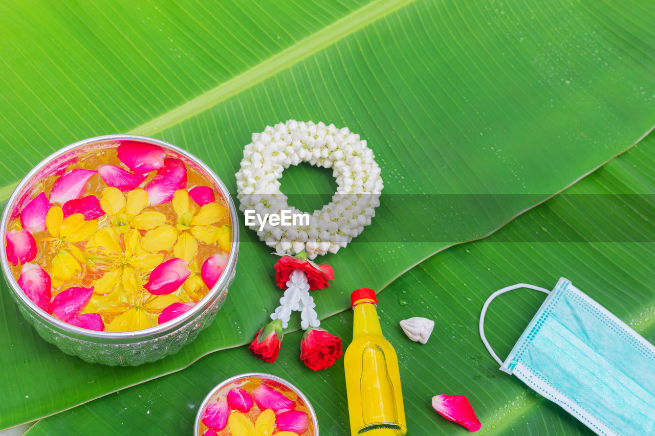 green, food and drink, food, banana leaf, flower, leaf, plant part, freshness, high angle view, no people, leaves, healthy eating, wellbeing, multi colored, nature, fruit, green background, plant, directly above, still life, bowl, flowering plant, sweet food