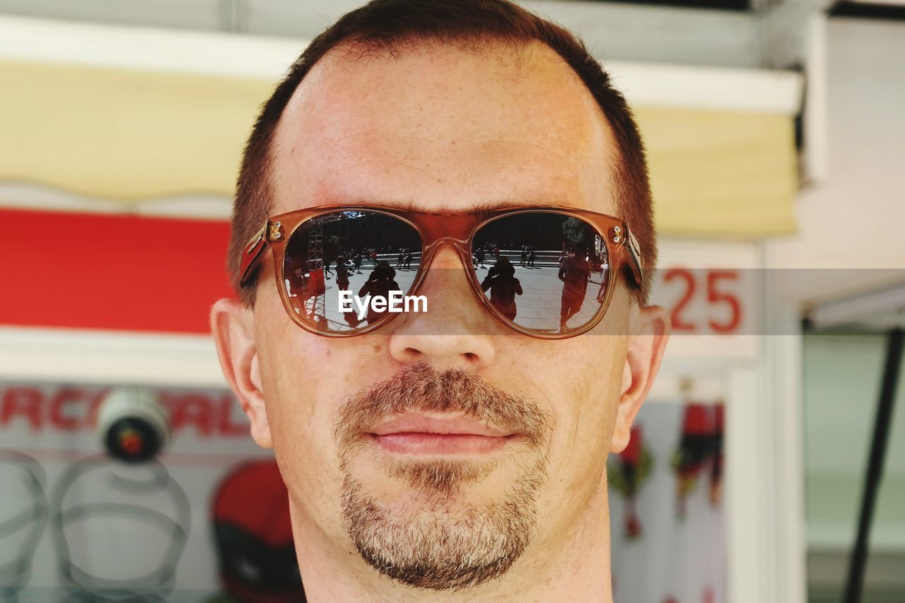 Close-up portrait of smiling mature man wearing sunglasses