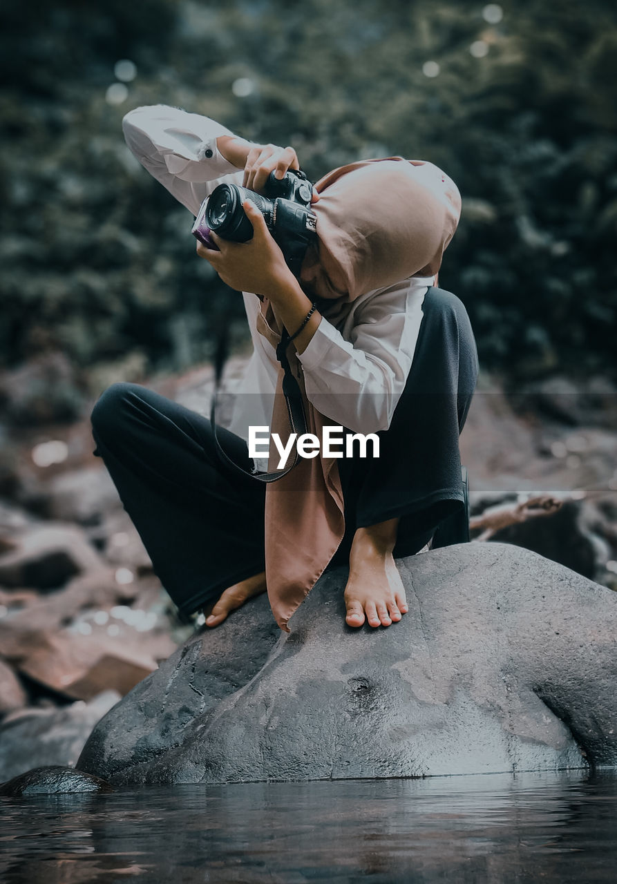 WOMAN PHOTOGRAPHING WITH UMBRELLA