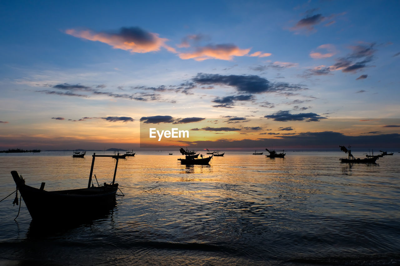 SILHOUETTE BOATS IN SEA AGAINST ORANGE SKY