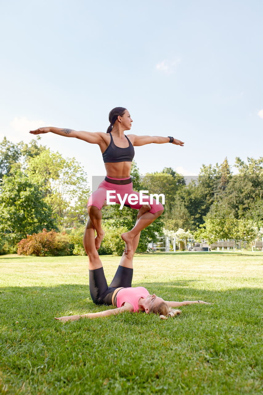 full length of woman doing yoga on field against clear sky