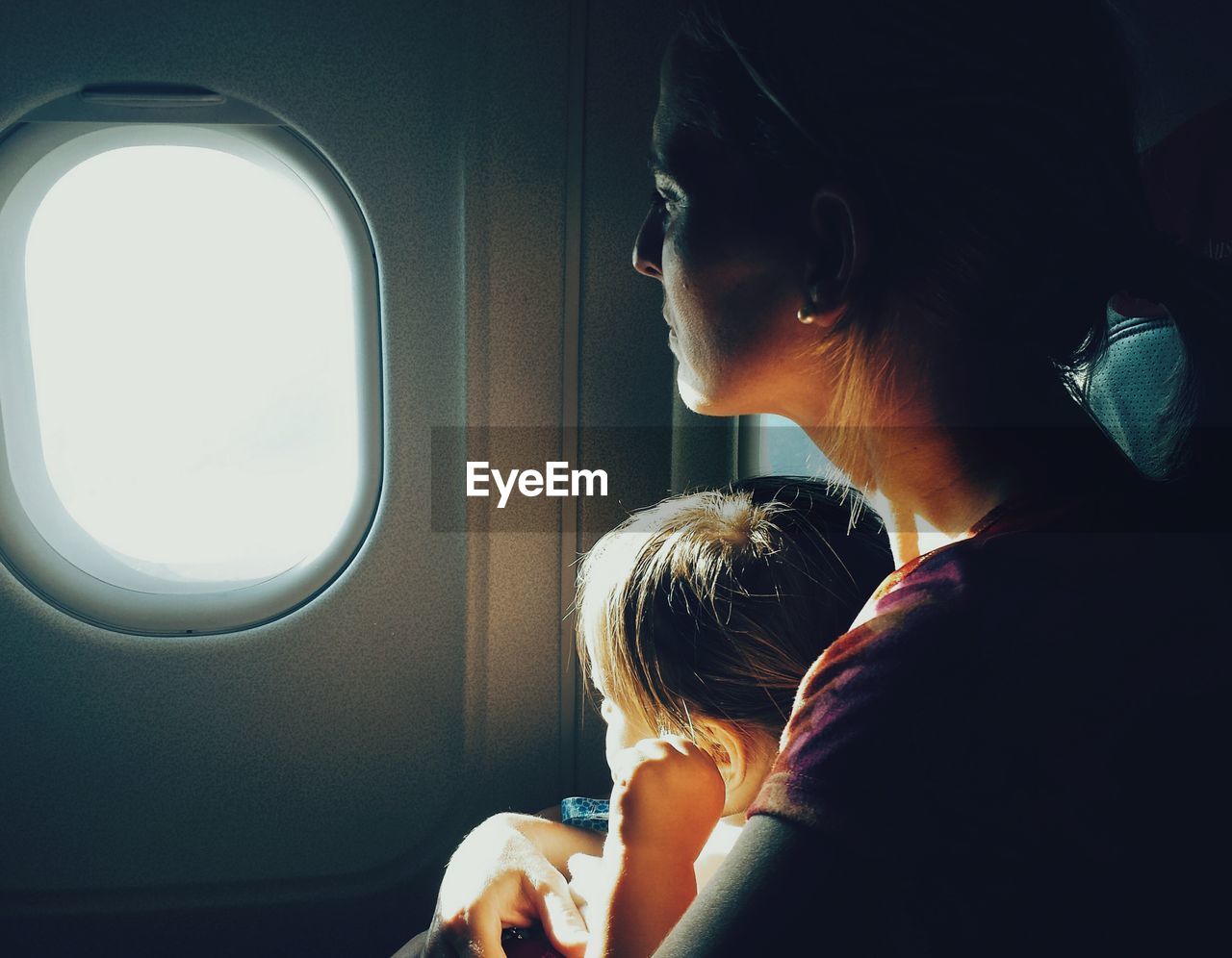 Mother with daughter by window in airplane