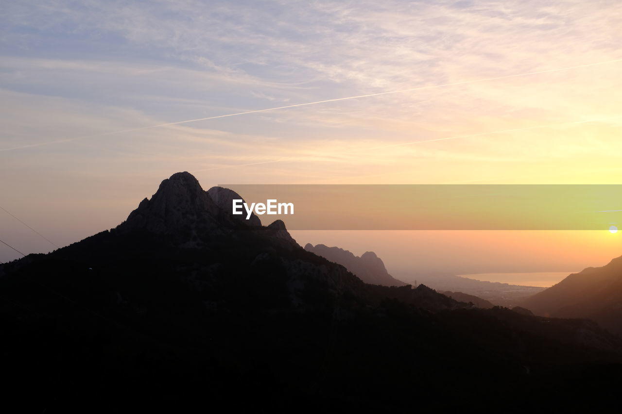 SCENIC VIEW OF SILHOUETTE MOUNTAIN AGAINST SKY DURING SUNSET