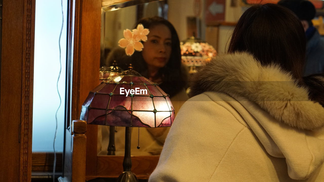 Woman looking in mirror at home