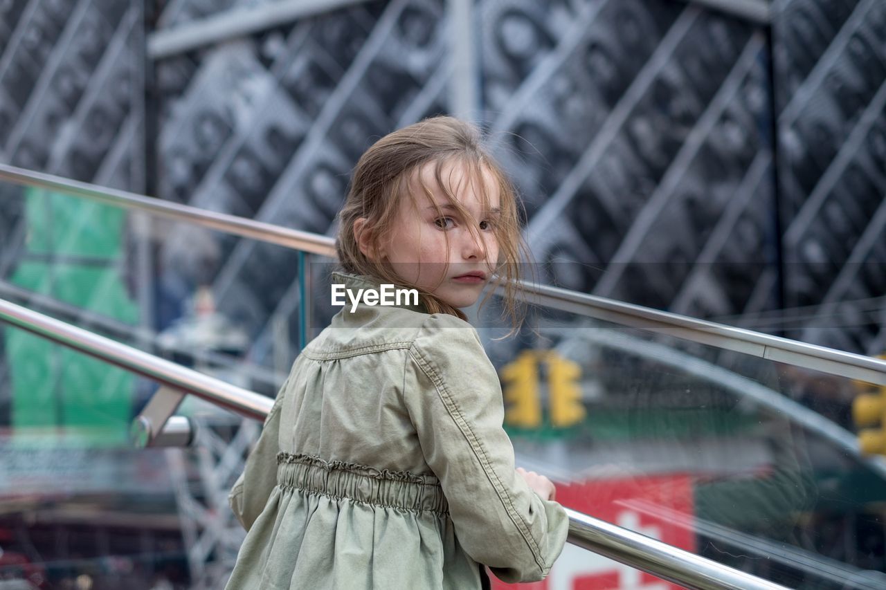 Girl standing on railing at time square new york