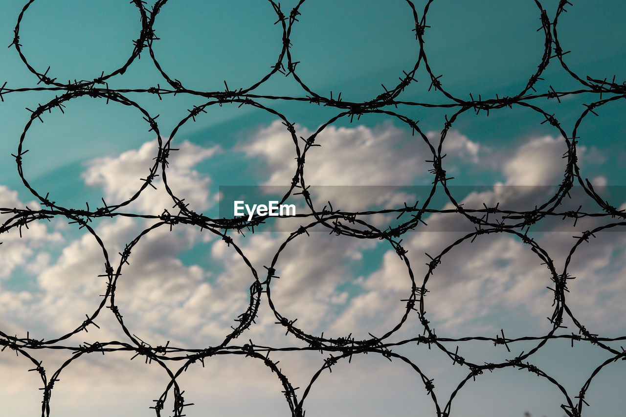 Full frame shot of chainlink fence against blue sky