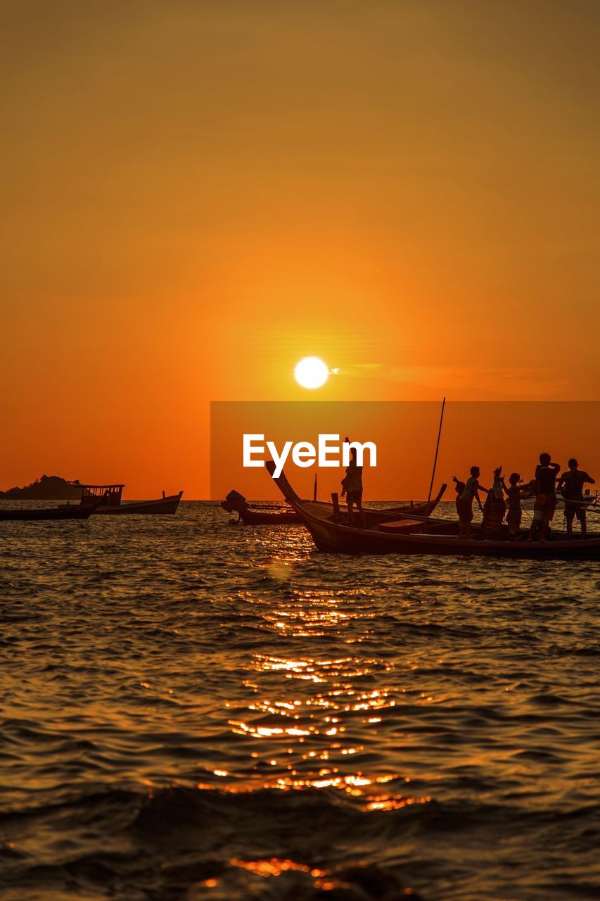 People in boat on sea during sunset