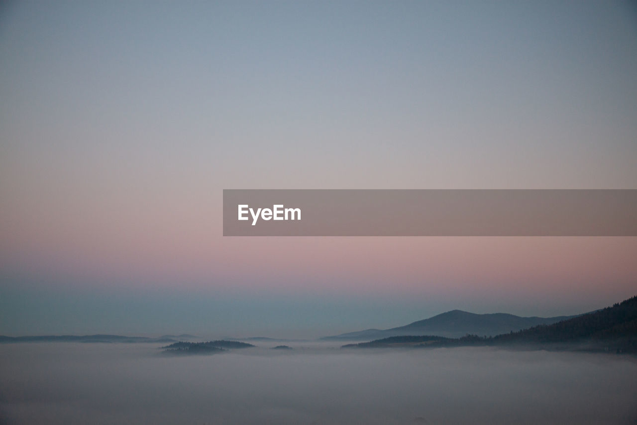 Scenic view of mountains against clear sky during sunset