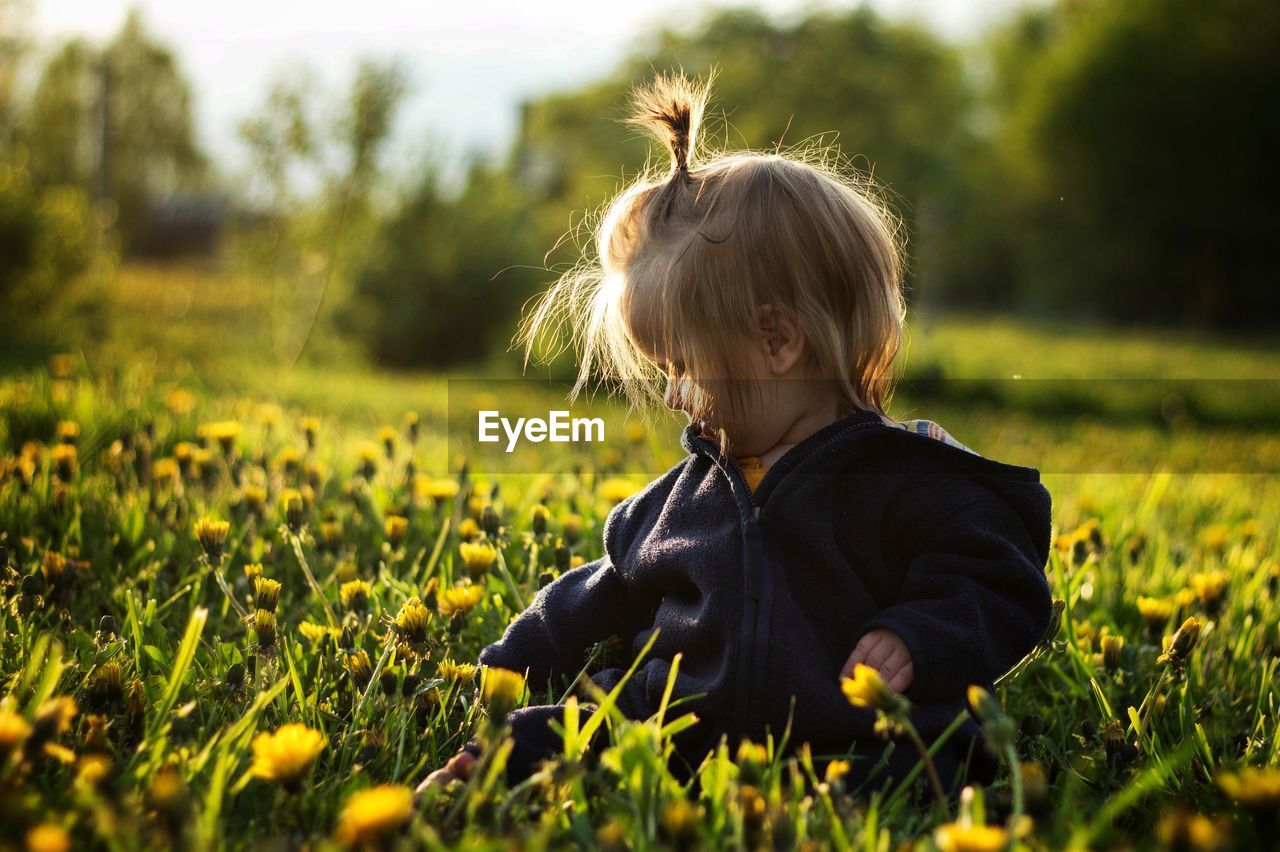 Rear view of baby girl on field