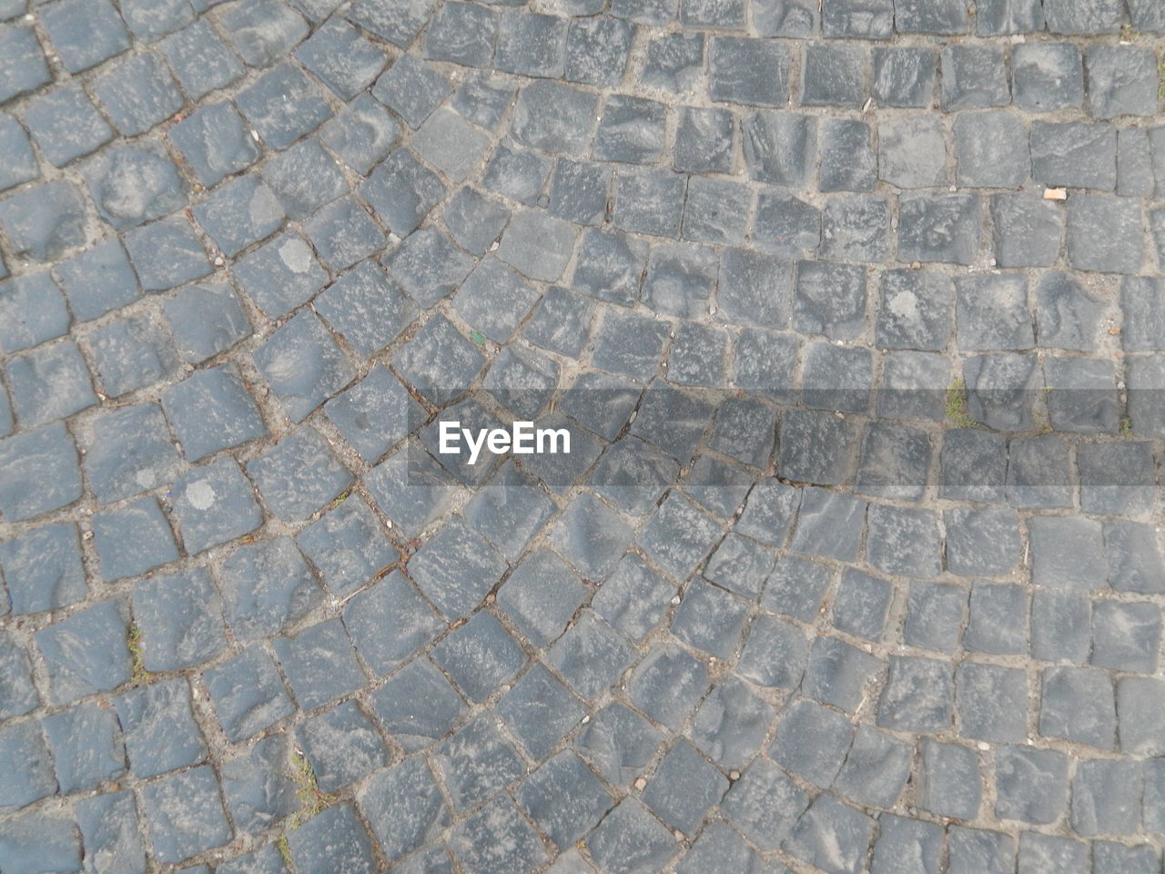 HIGH ANGLE VIEW OF STONE COBBLESTONE STREET