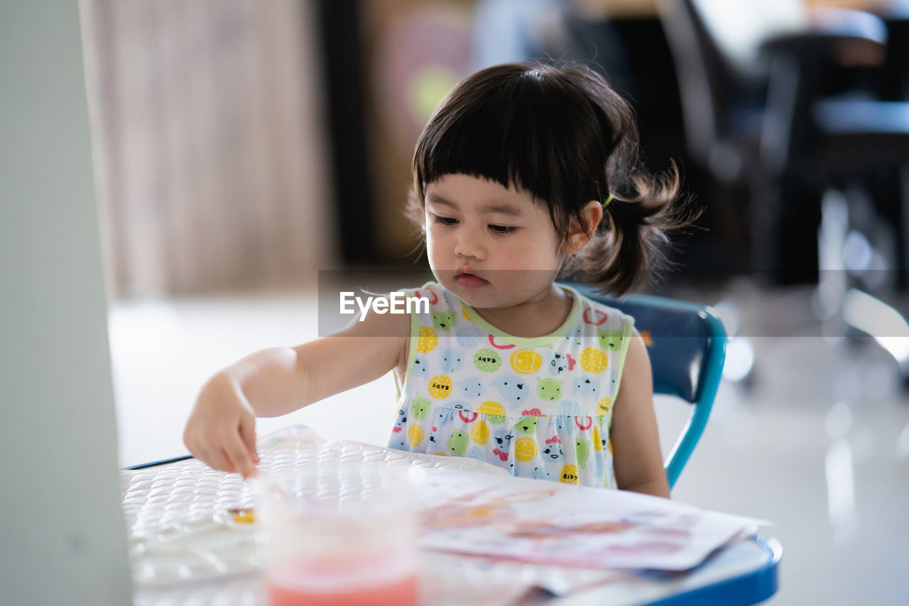 Portrait of cute girl preparing food on table