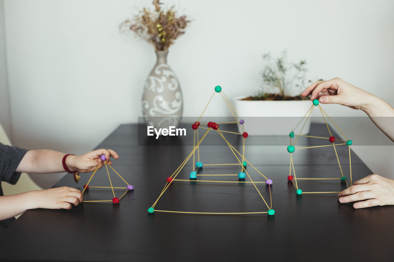 Mother and son making geometric shapes from sticks and play dough.