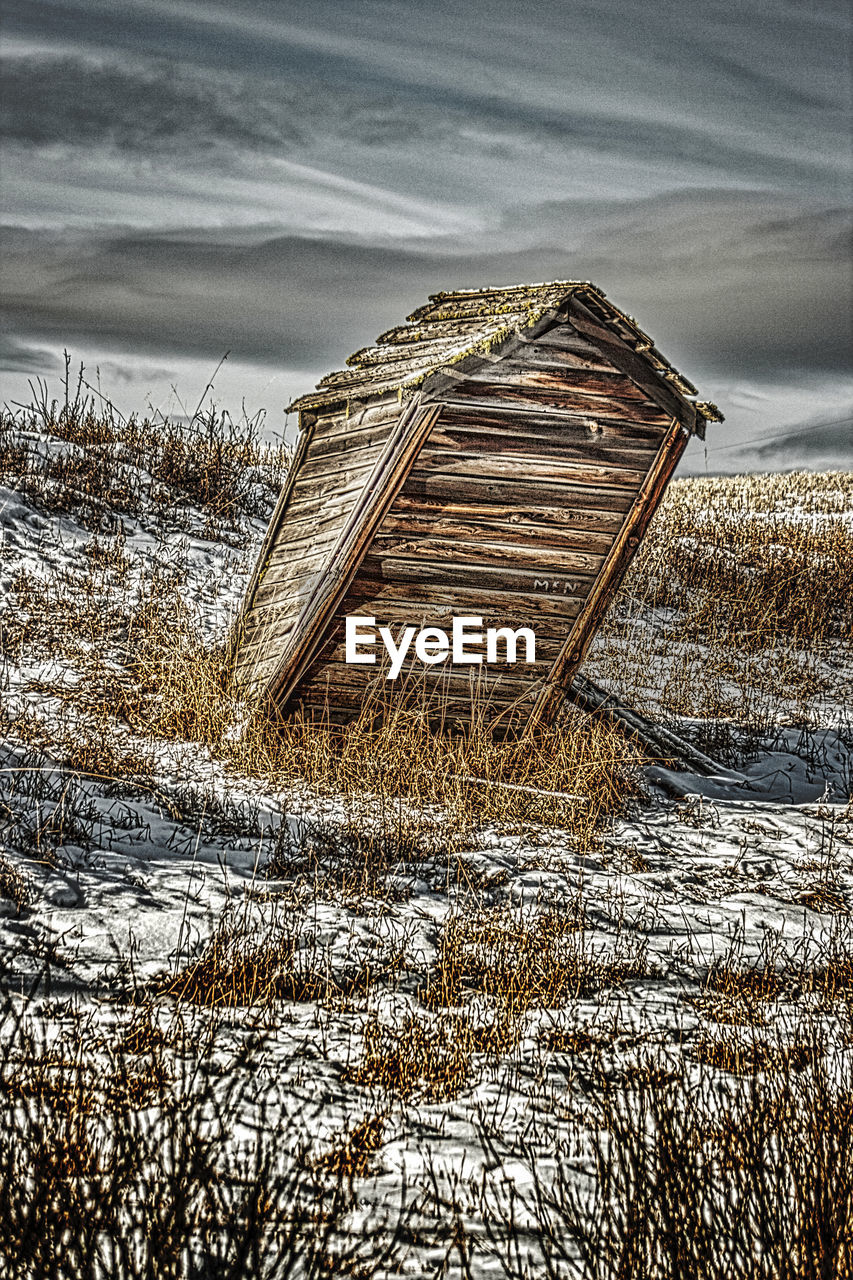 ABANDONED BUILDING ON FIELD DURING WINTER