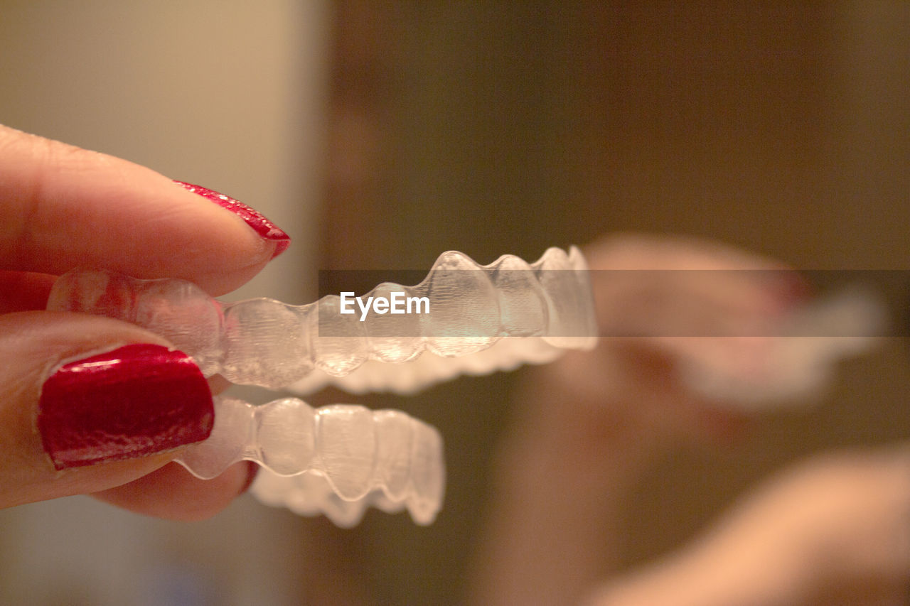 Cropped hand of woman holding dental aligner