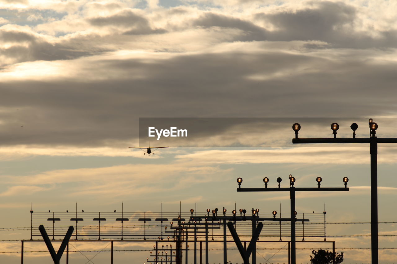 Plane flying against sky during sunset