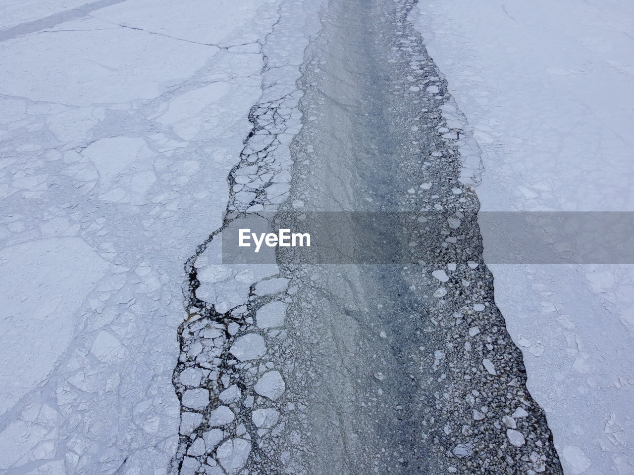 HIGH ANGLE VIEW OF FROZEN WATER IN WINTER