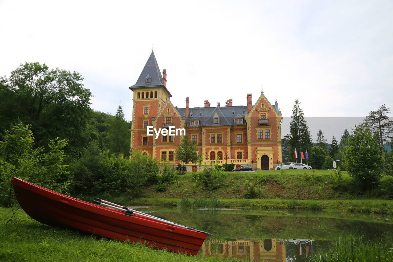 BUILT STRUCTURE BY RIVER AGAINST BUILDINGS