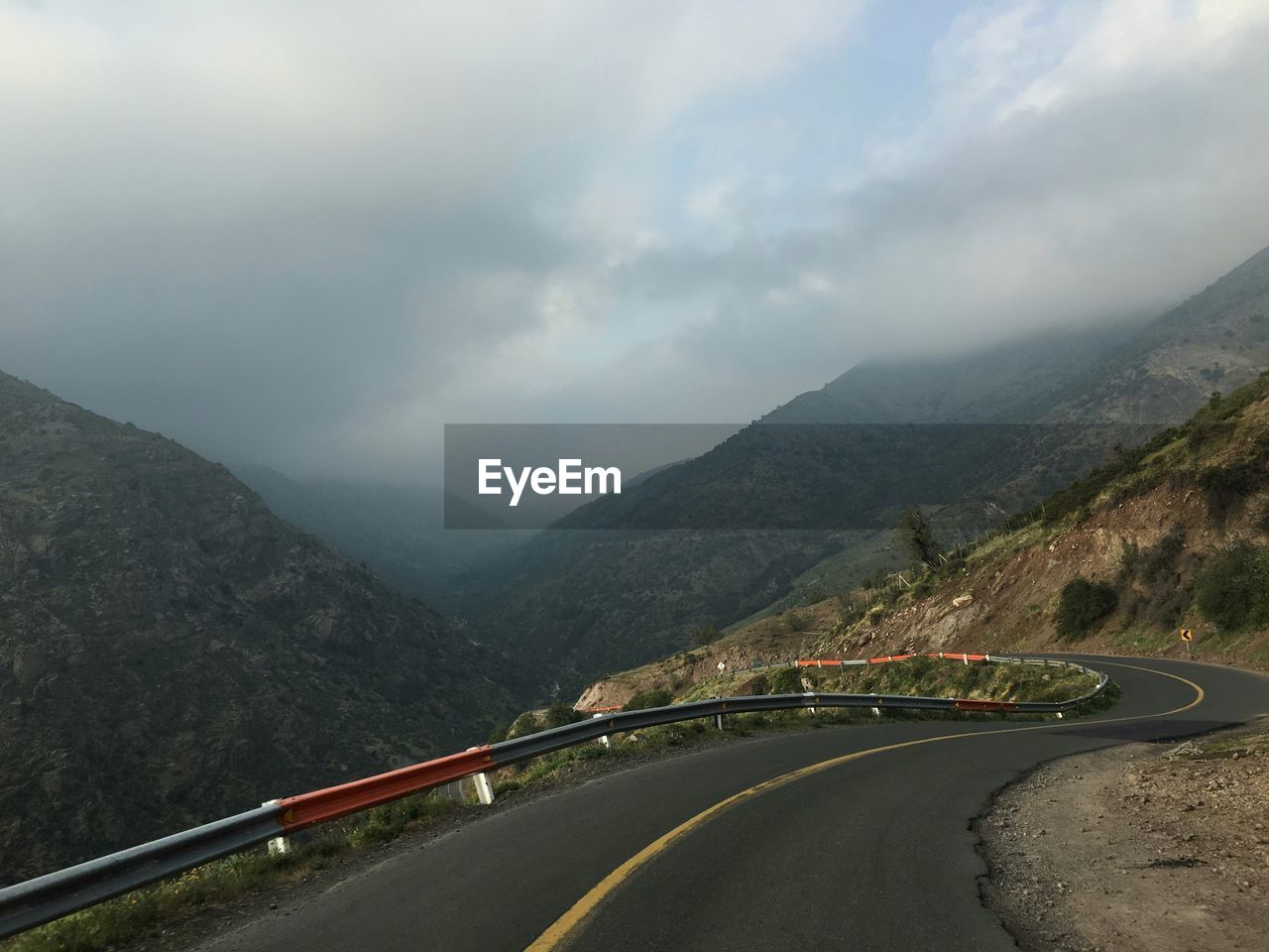 Mountain road against cloudy sky