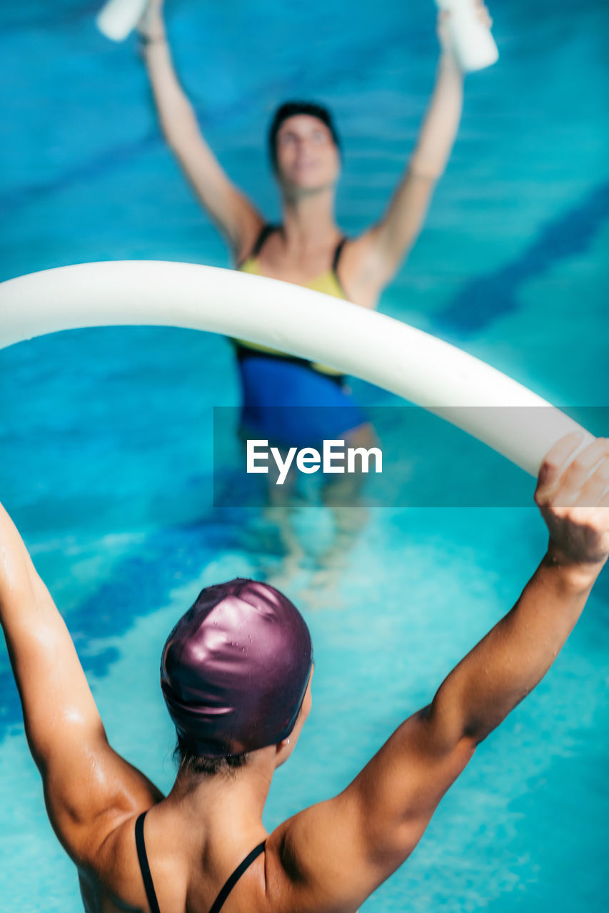 High angle view of swimmers exercising in swimming pool