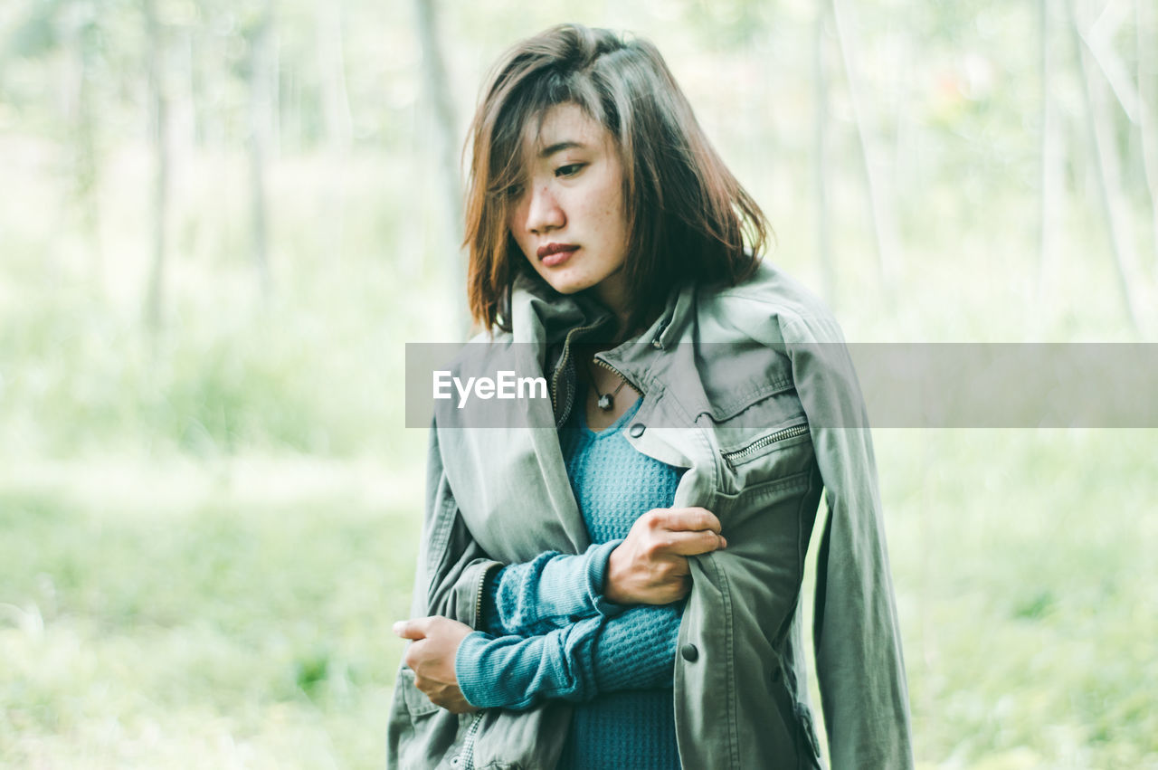 Close-up of woman in jacket standing outdoors