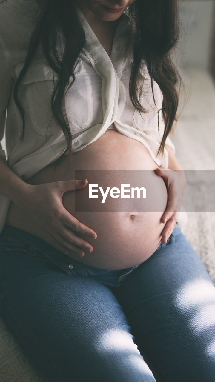 Midsection of woman sitting at home