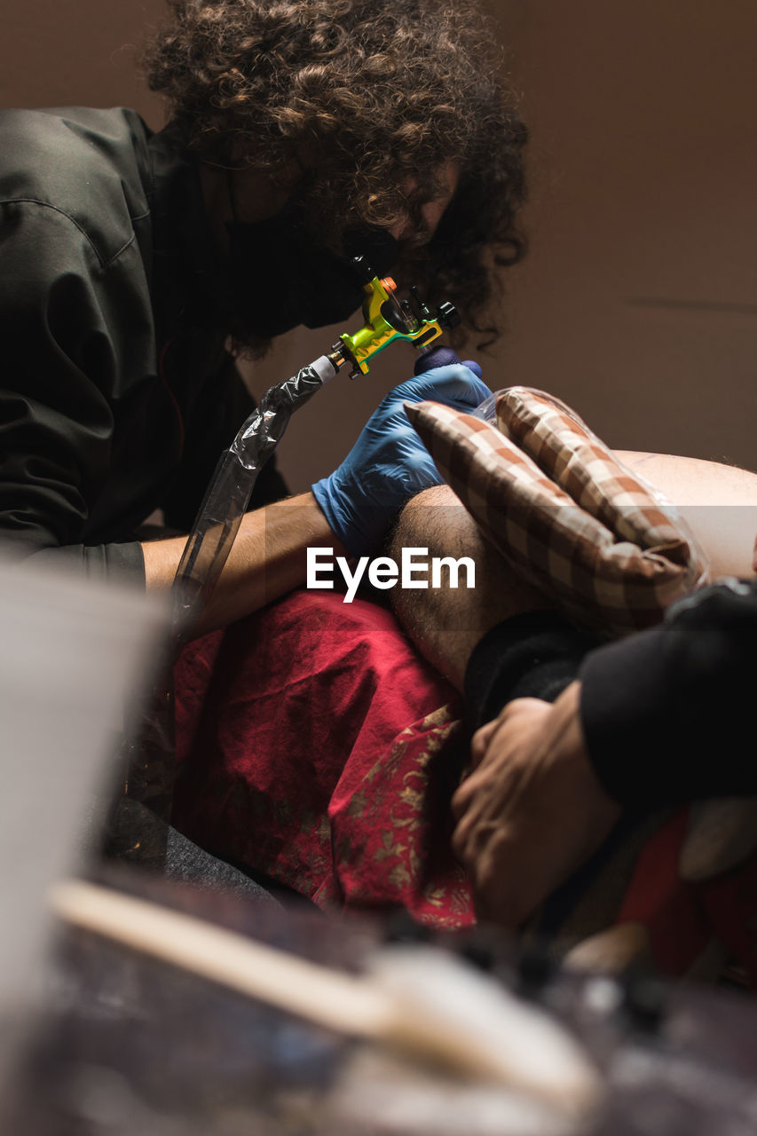 Tattooist working with client in salon