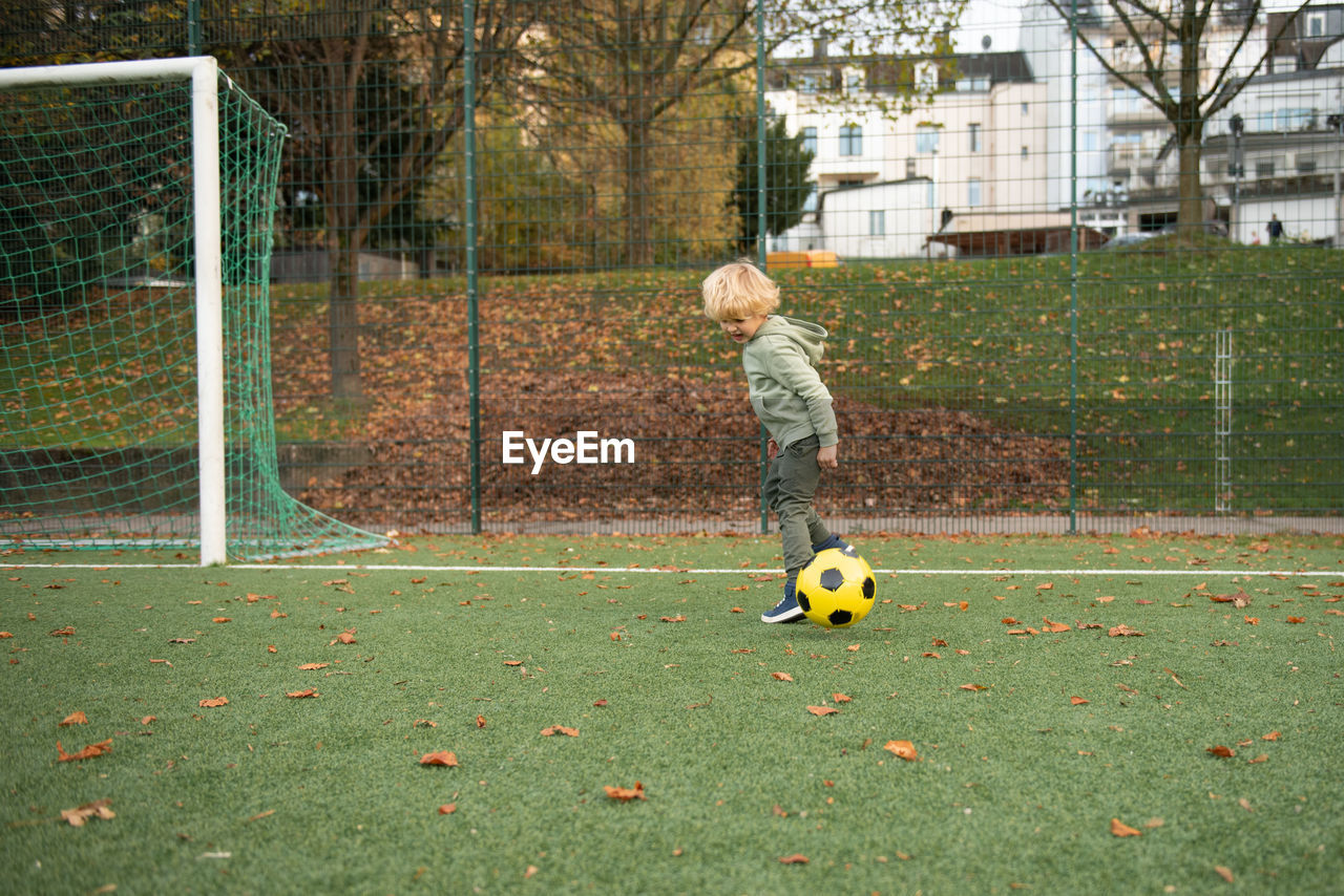 A little boy plays soccer on the soccer field